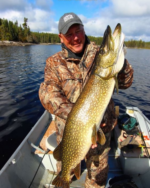 Man with freshly caught Northern Pike on boat
