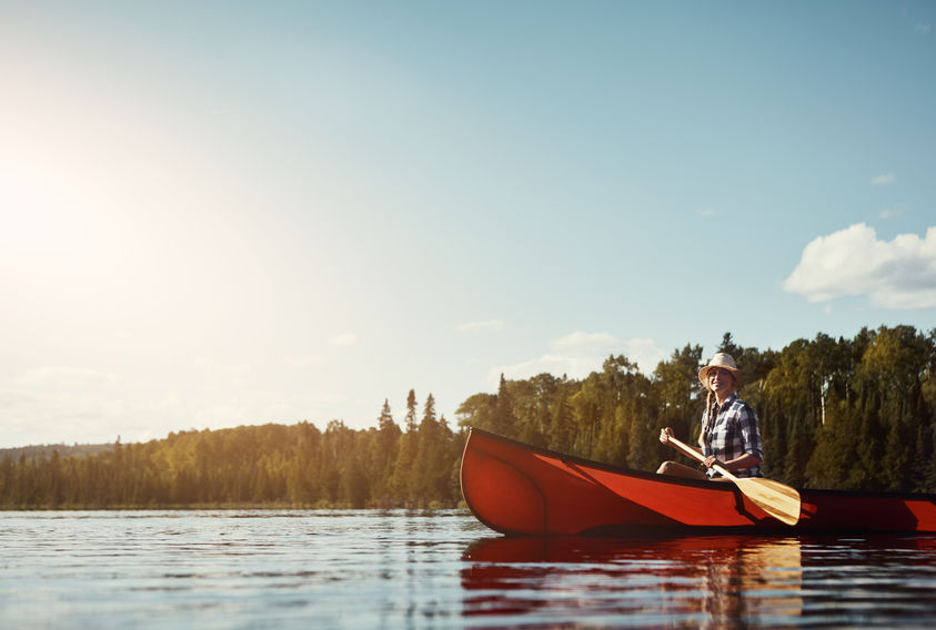 Woman enjoying a paddle down the lake in a canoe in Northwestern Ontario. 